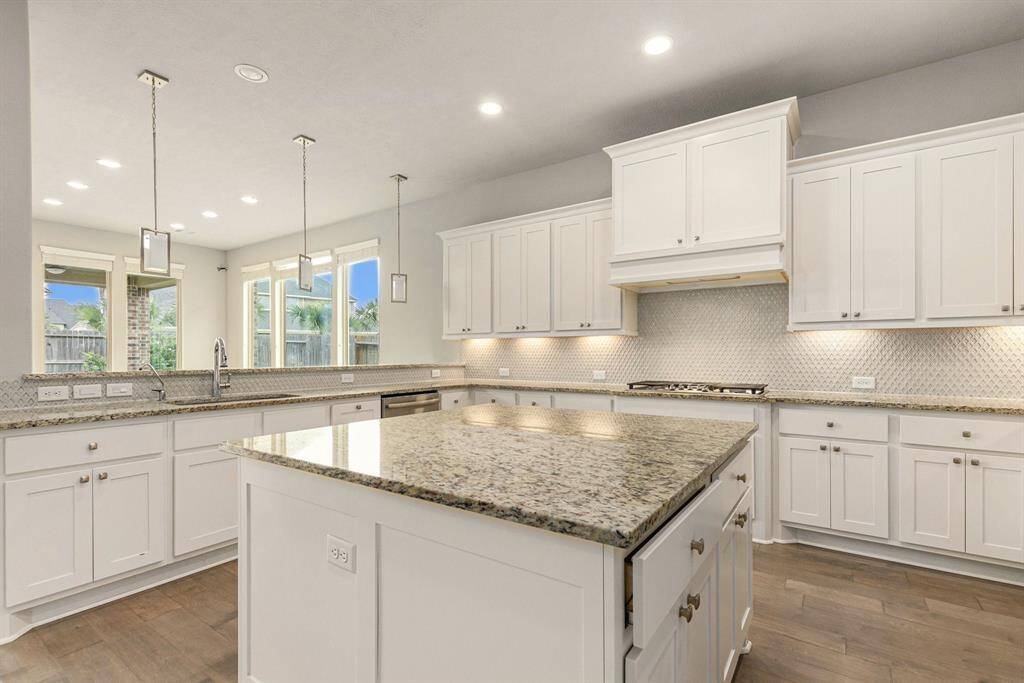 Massive kitchen featuring beautiful countertops, a large island, stainless steel appliances, and ample cabinetry—perfect for any home chef!