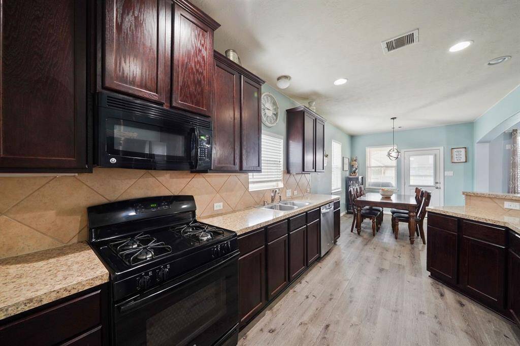 Spacious kitchen with plenty of cabinetry and countertop space. The kitchen has a pantry, breakfast bar and connected to the breakfast room. Notice the natural light streaming through the windows.