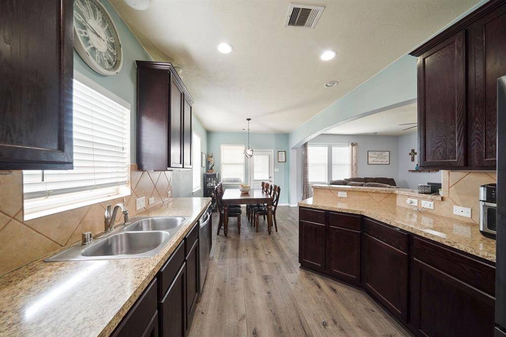 This is a bright, open-concept space featuring a kitchen, breakfast room, and family room to the right.