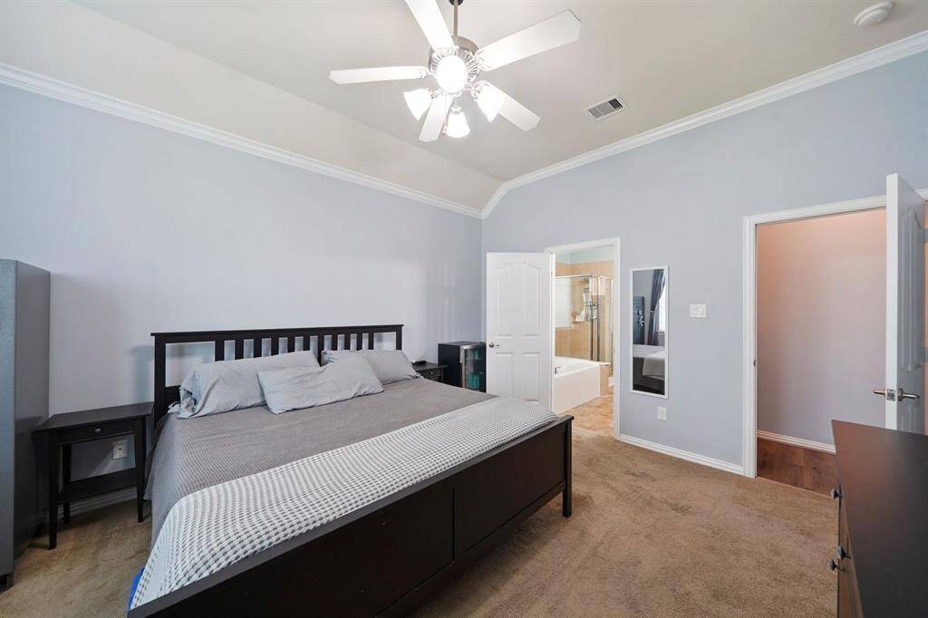 This spacious primary bedroom has direct access to an en-suite bathroom.