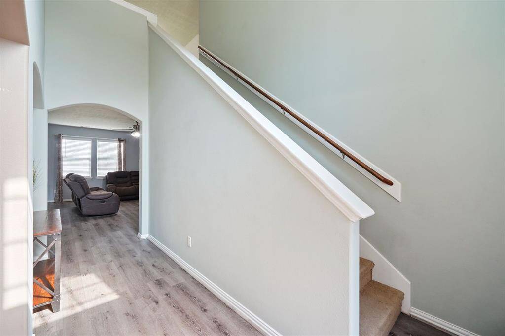 In this view, the stairway leads to the upper level while an arched opening hints at a cozy living space beyond.