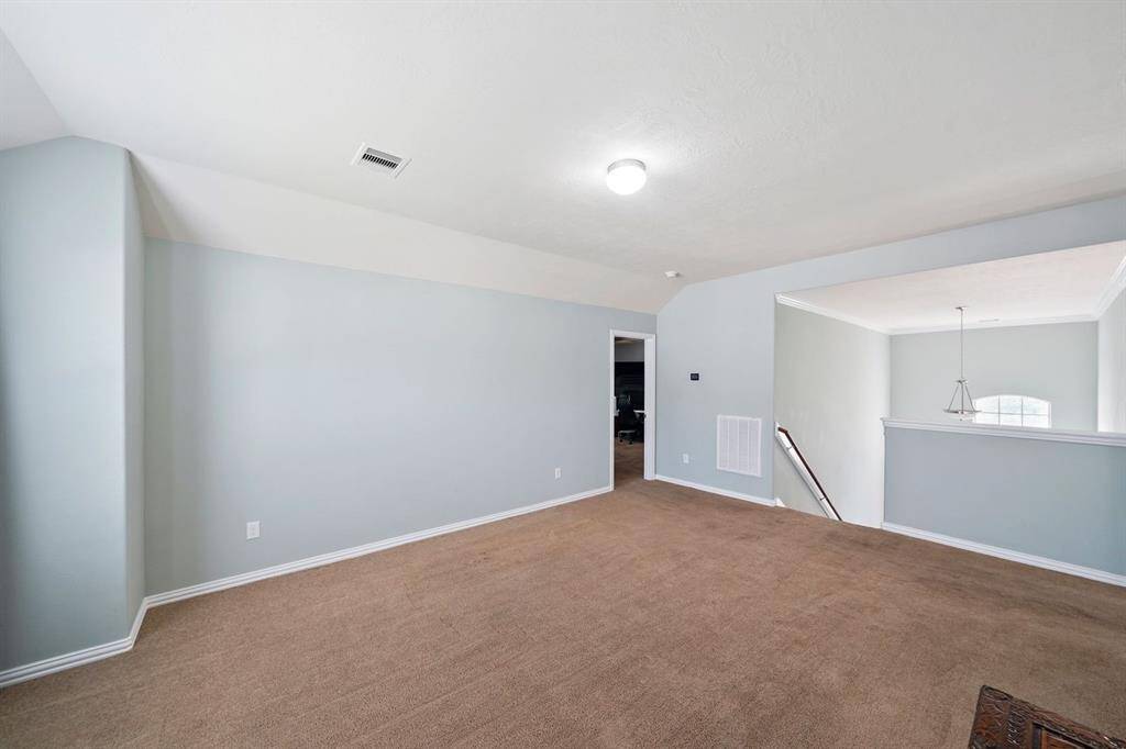 This photo is another angle of the game room featuring a half-wall overlooking the stairs and entry way, creating an open and inviting atmosphere.