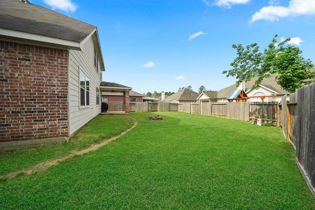 This is a nice size backyard enclosed by a wooden privacy fence. The exterior of the house features brick and siding, and there's a small patio area.