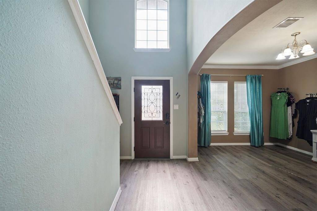 Entryway with high ceilings, decorative front door, and an inviting, open feel.