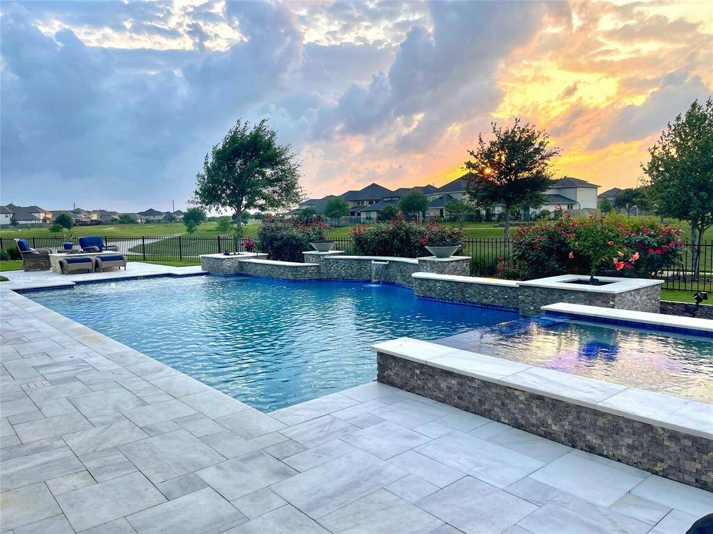 Spectacular views from the expansive backyard entertainment area. Note, the fire pit in the foreground is great for roasting marshmallows after an afternoon swim. Colorful pool lights make a fun backdrop.