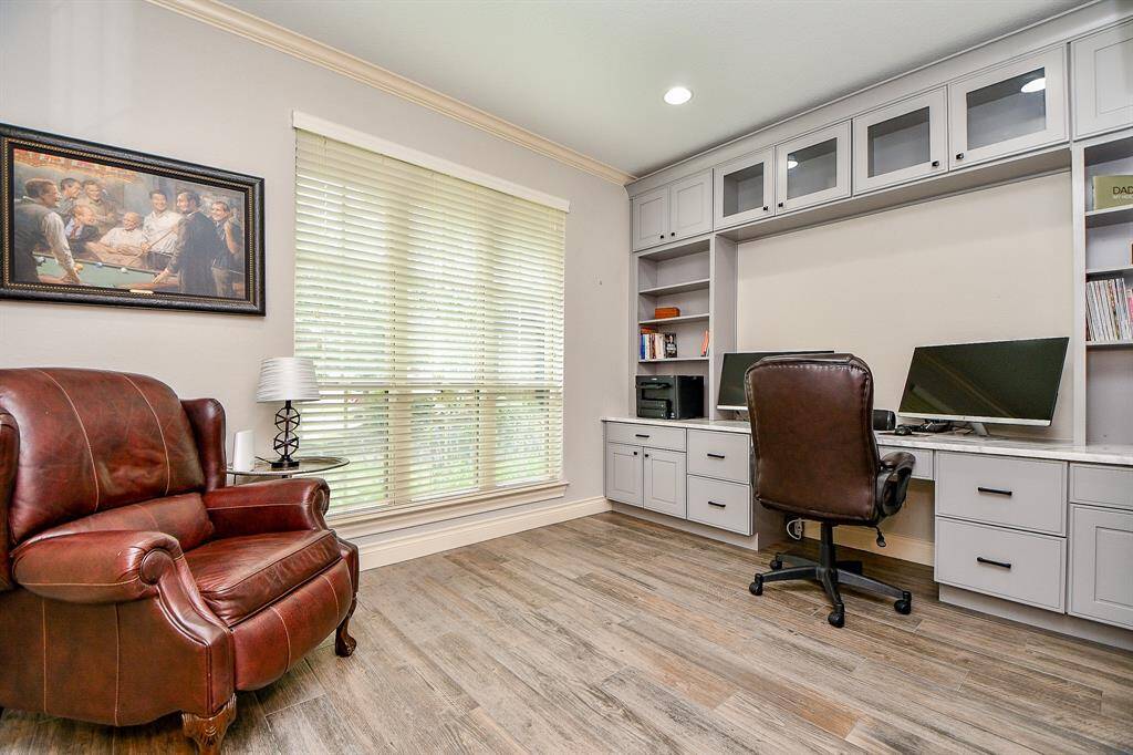 A floor-to-ceiling triple window naturally lights this exquisite home office/study, with spectacular built-in storage and desk space.