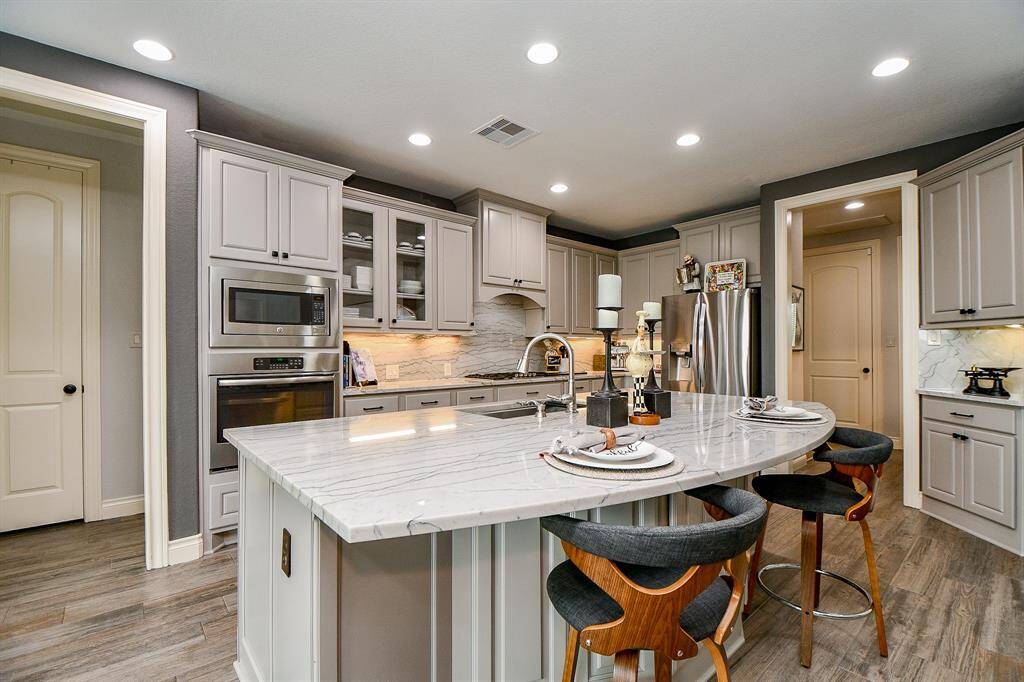 This is a cook's dream kitchen, not only for its visual purity, but also for its true 'workability'! Wherever you land, there's counter space, cabinetry and appliances to make your tasks easier! And, just look at this semi-circular extended island counter top, which easily invites some comfy stools.