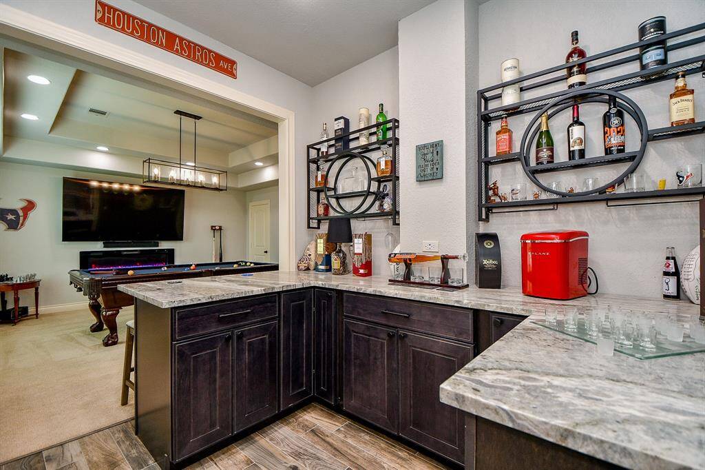 The custom built bar offers Quartzite counters and custom shelving to display your finest!