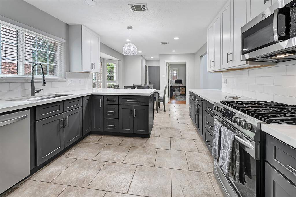 remodeled kitchen with quartz counter top, new cabinets, and gas appliance