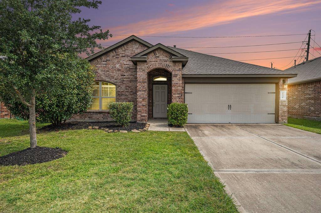 Front of home with nice landscaping and beautiful sunset.