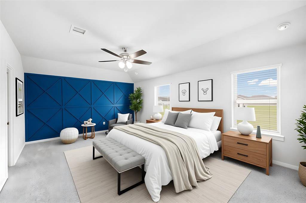 The virtually-staged primary bedroom shows a gorgeous blue accent wall that adds so much character and style to the room.