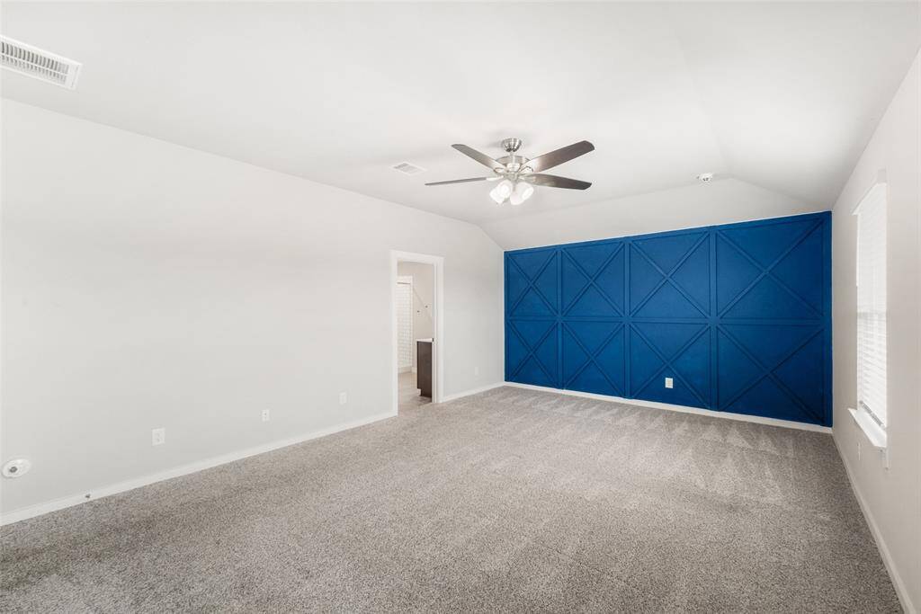 The upgraded ceiling fan and carpet add to the room's appeal.  Through the door straight ahead is the primary bathroom.