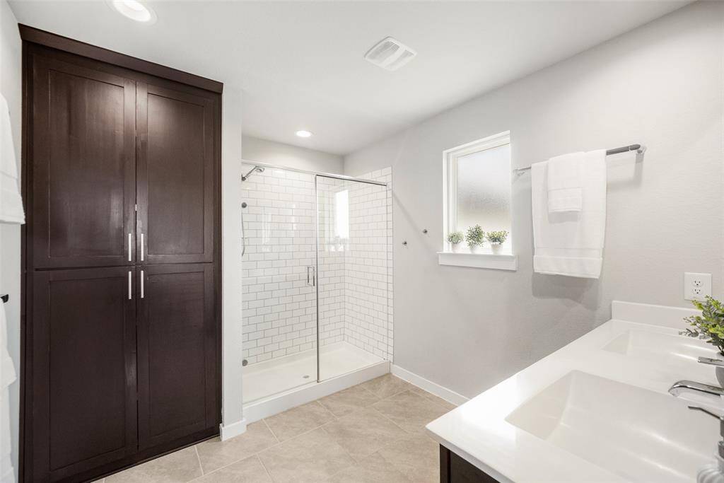 Gorgeous custom cabinets were added to this already-wonderful primary bathroom with double sinks and a super shower.