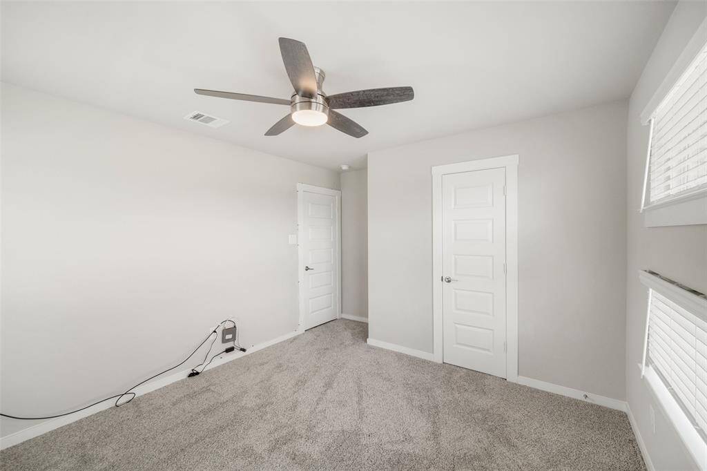 Here is a second view of Bedroom 1 of 4 showing the closet at right.  All four bedrooms have upgraded carpet and ceiling fans.