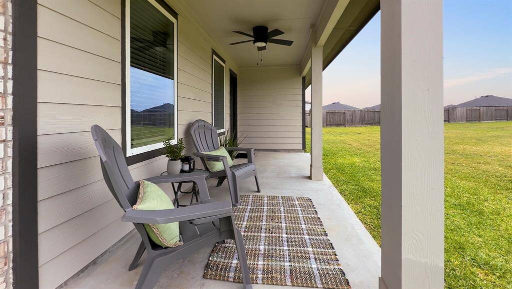 The covered back patio with upgraded ceiling fan is a shady spot for relaxing outdoors.