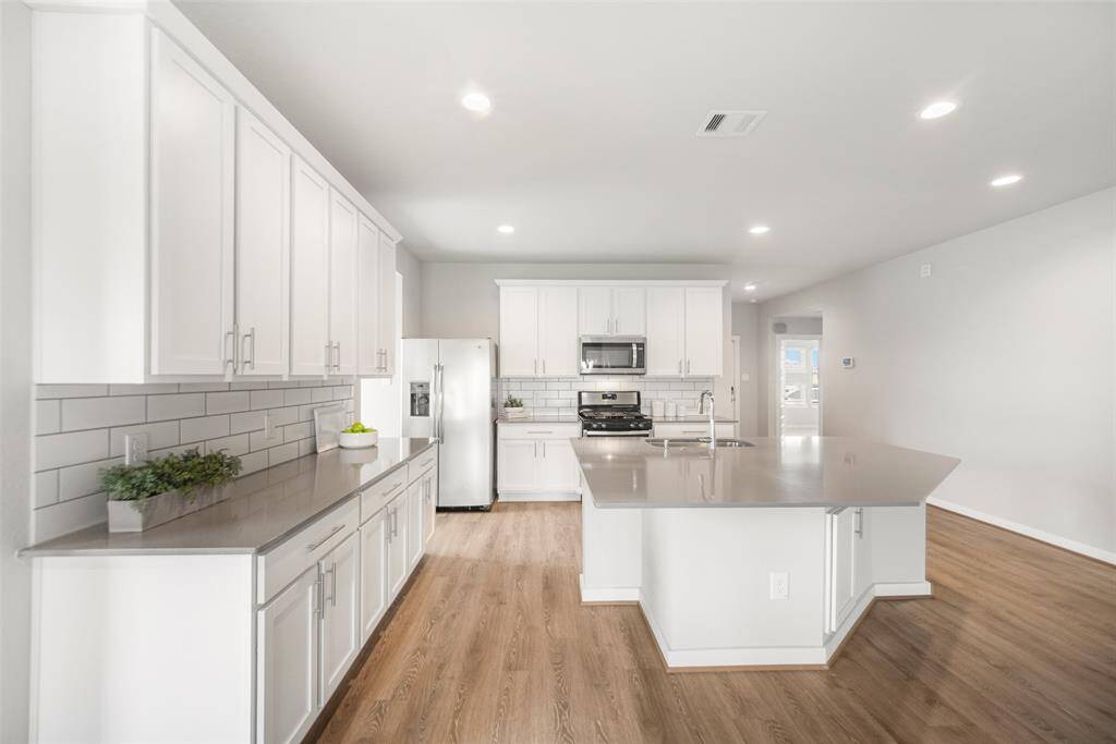 As seen here, the kitchen has a sizable island plus plentiful cabinet and drawer space. In addition, there's an ample-sized pantry for food storage.