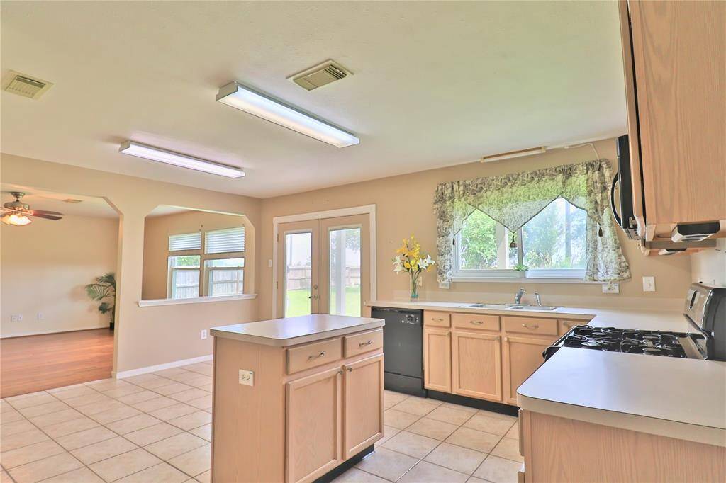Bright kitchen with ample natural light, and tile floor, double door leads to backyard.