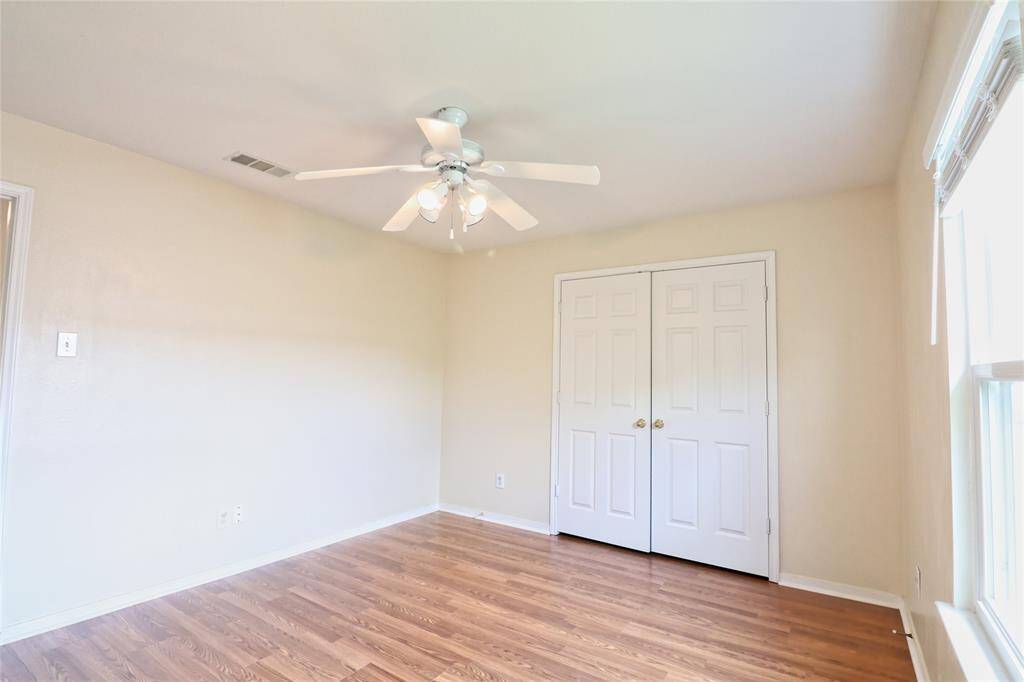 secondary bedroom  room 2 with a ceiling fan and double closet doors.