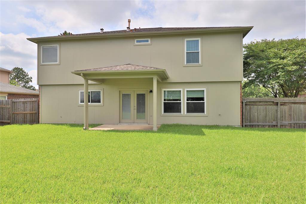 a covered patio and a spacious, fenced backyard, ideal for outdoor activities and relaxation.