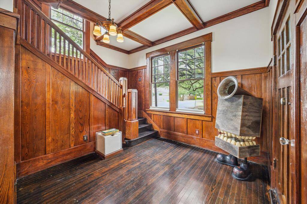 The spacious living area is awash in natural light and features a box ceiling, built in shelving and a wood burning fireplace.