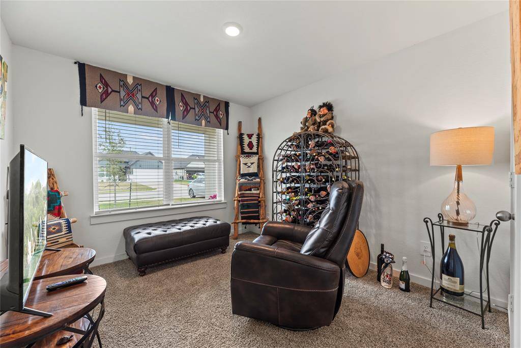 The bedroom at the front of the house is cozy and bright, featuring soft carpet underfoot for added comfort. A large window offers a peaceful view of the front yard, filling the room with natural light and creating a serene atmosphere. The light walls enhance the sense of space, making the room feel airy and inviting, while providing a neutral backdrop for personalized decor.