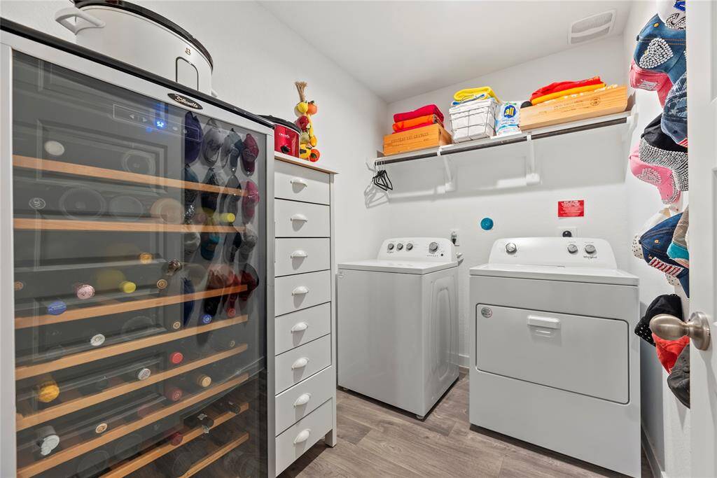 The spacious laundry room offers plenty of room for both functionality and organization. It features a shelf for convenient storage, perfect for detergents, cleaning supplies, or other essentials. There’s also ample space to fit an extra fridge, making it a practical addition for storing beverages or extra groceries. The room is well-designed to keep everything tidy and easily accessible, adding to the overall efficiency of the home.