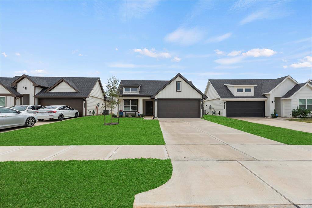 The home is complemented by a spacious front lawn, offering a peaceful, open area right next to a long, double driveway. The driveway leads up to the house, providing ample parking space.