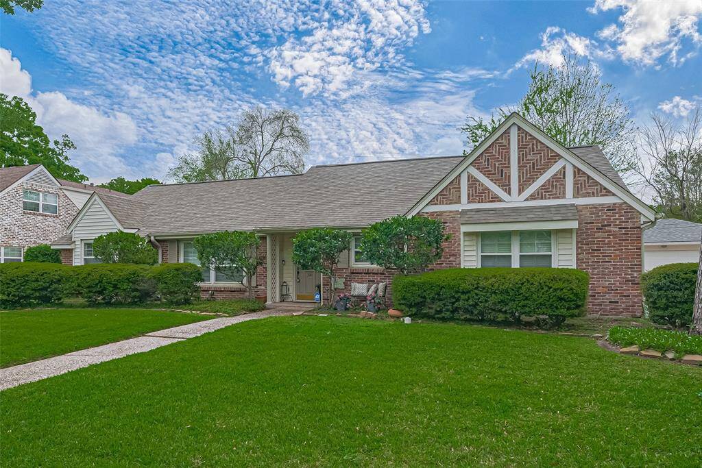 Charming single-story brick home with a gable roof, featuring a well-maintained lawn and mature landscaping. It offers a welcoming front porch and large windows, providing excellent curb appeal in a quiet neighborhood.
