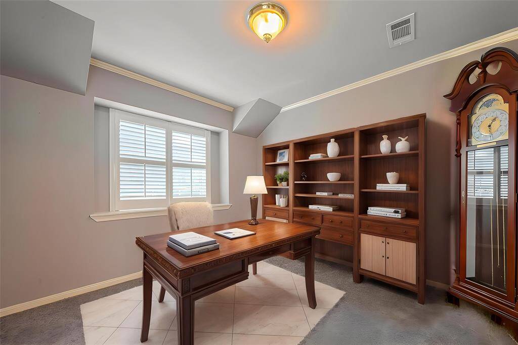 Virtual Staging - This photo showcases a well-lit home office with a large window, classic wooden desk, built-in shelves, and a grandfather clock, providing a cozy and functional workspace.