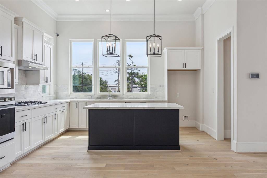 elegant kitchen with SS Fisher Paykel appliances, white marble backsplash, quartz countertops