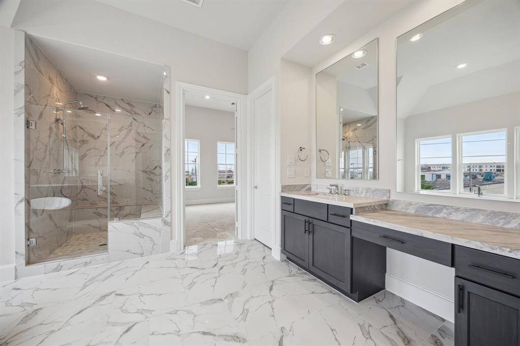 enormous primary bathroom with epic large shower and sit down vanity