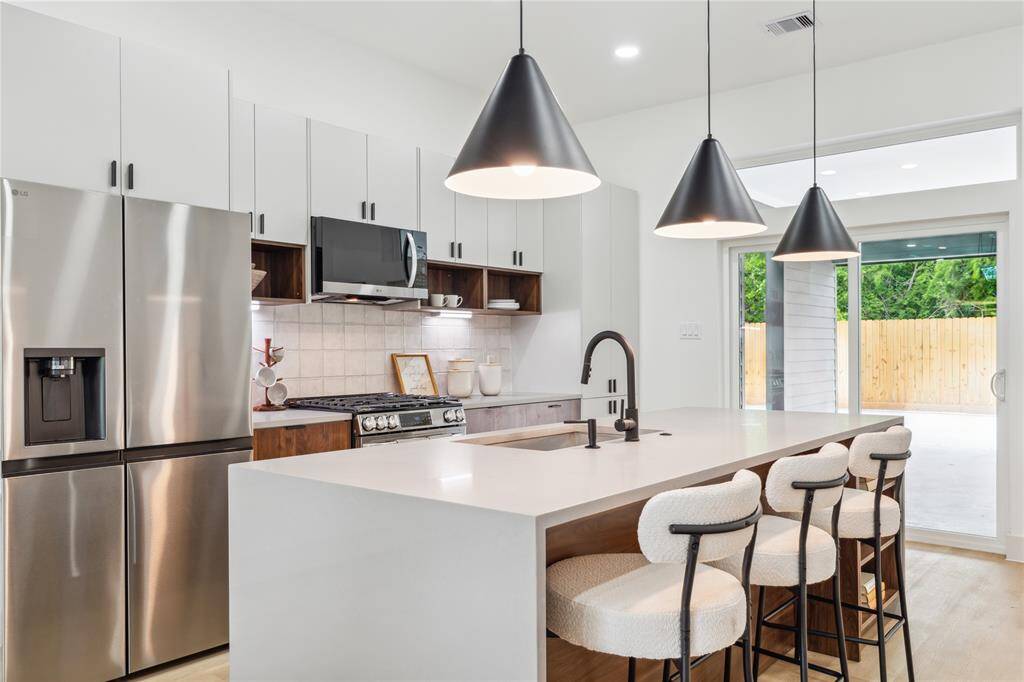 With striking pendant lighting, sleek finishes, and a spacious island, this kitchen is designed to host everything from lively gatherings to quiet, memorable moments.