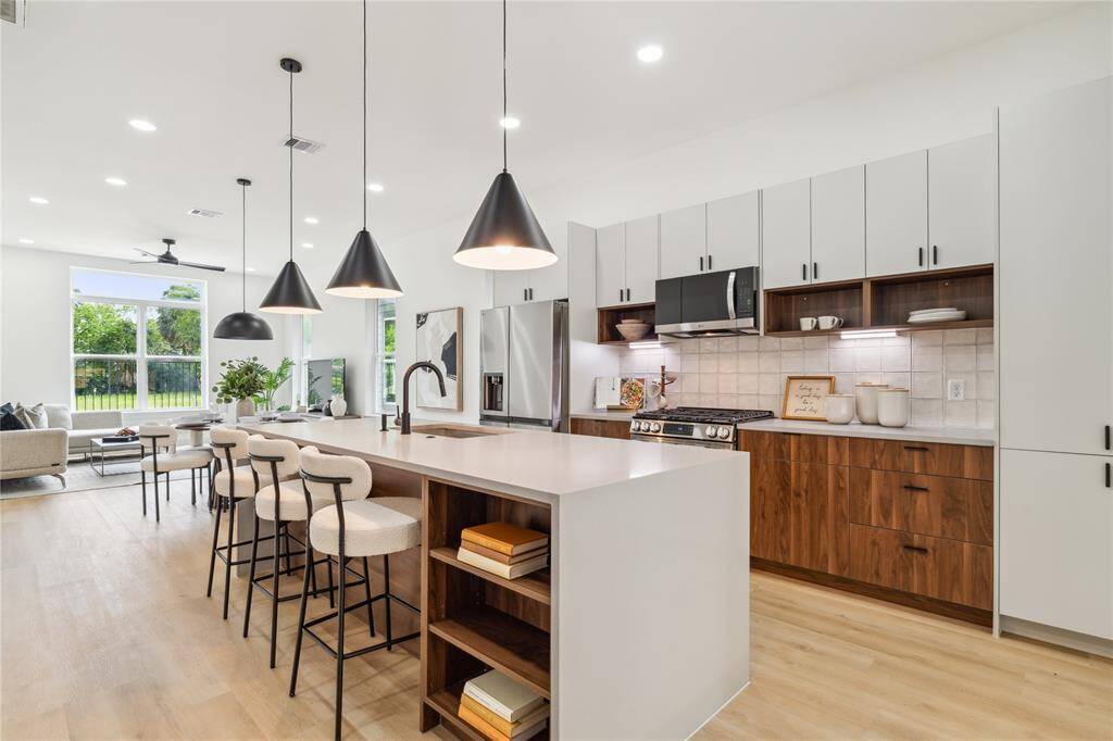 With oversized picture windows, a waterfall-edge island, and an effortless connection to the living space, this kitchen truly becomes the heart of the home.