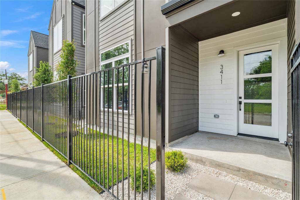 A gated entry and covered porch offer both privacy and a warm welcome, setting the tone for contemporary city living.