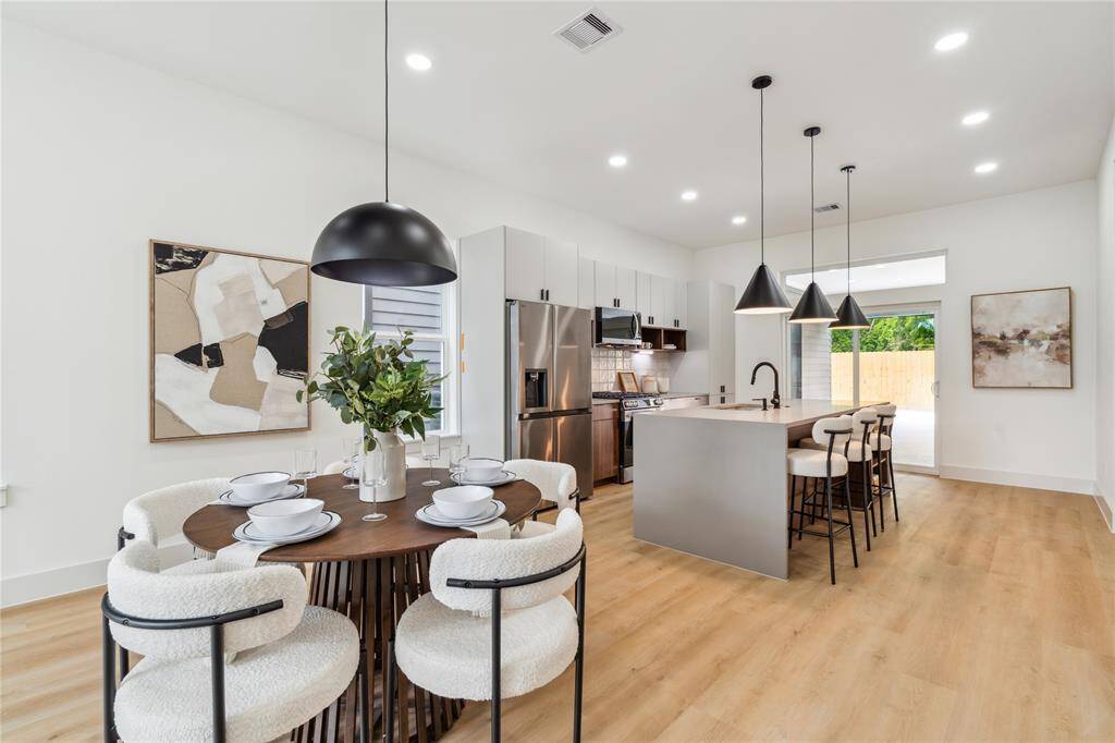 The open-concept kitchen and dining area blends crisp modern finishes with warm natural light—offering a grounded yet elevated setting for daily living and effortless hosting.