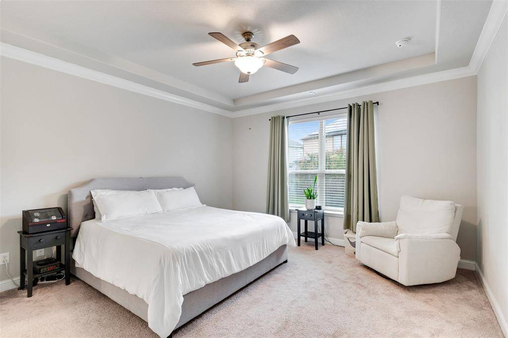 primary bedroom with crown molding and tray ceiling.