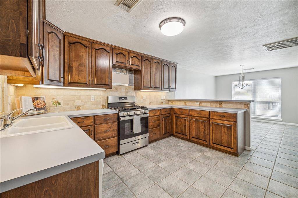 This kitchen boasts under cabinet lighting, a gas range, and a newly installed microwave [not pictured].