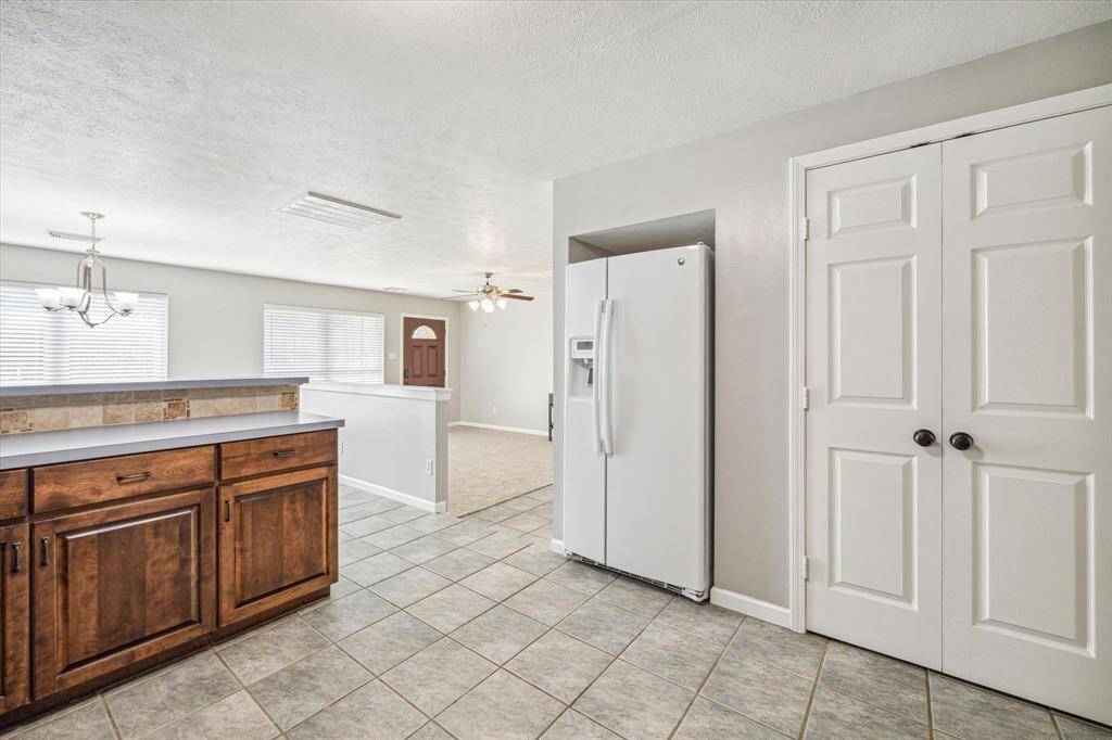 Full size side-by-side refrigerator included and situated right next to kitchen pantry.