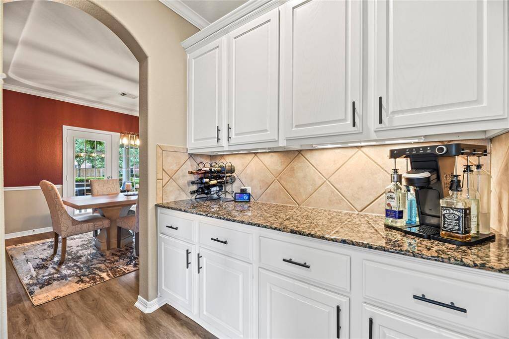 Perfectly situated between the kitchen and the formal dining room, ample white cabinetry and granite countertops add a posh space to store additional drinkware, wine, serving dishes, candles, and table linens! Be the host with the most!