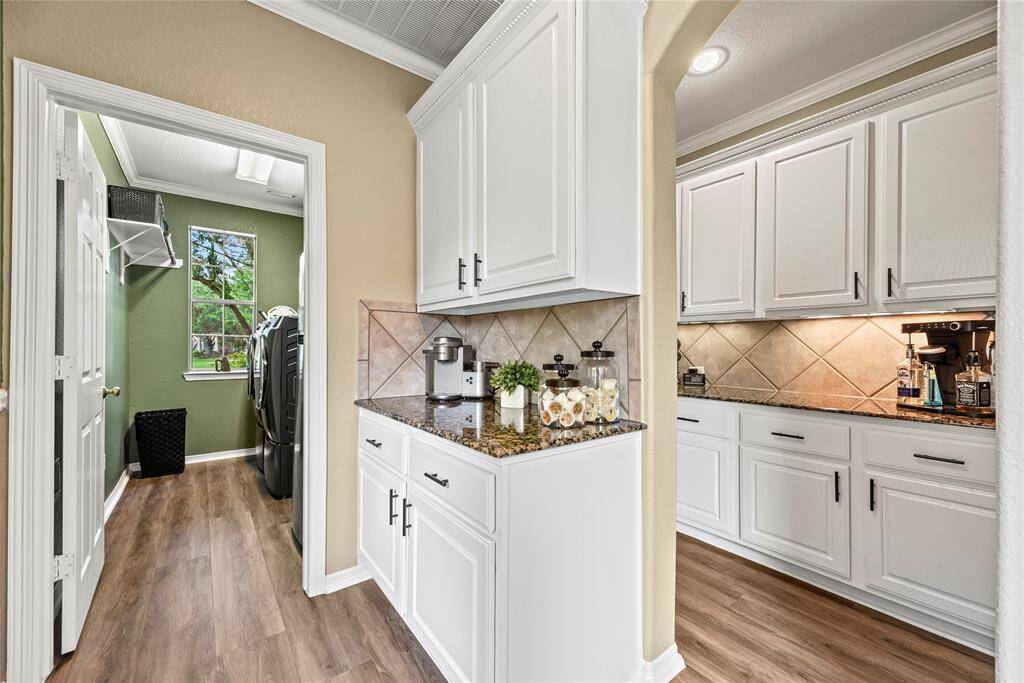 The butler's pantry offers extra storage and prep space, seamlessly connecting the kitchen to the dining area for effortless entertaining. With built-in cabinetry, countertop space, and room for small appliances, it keeps everything organized and out of sight.