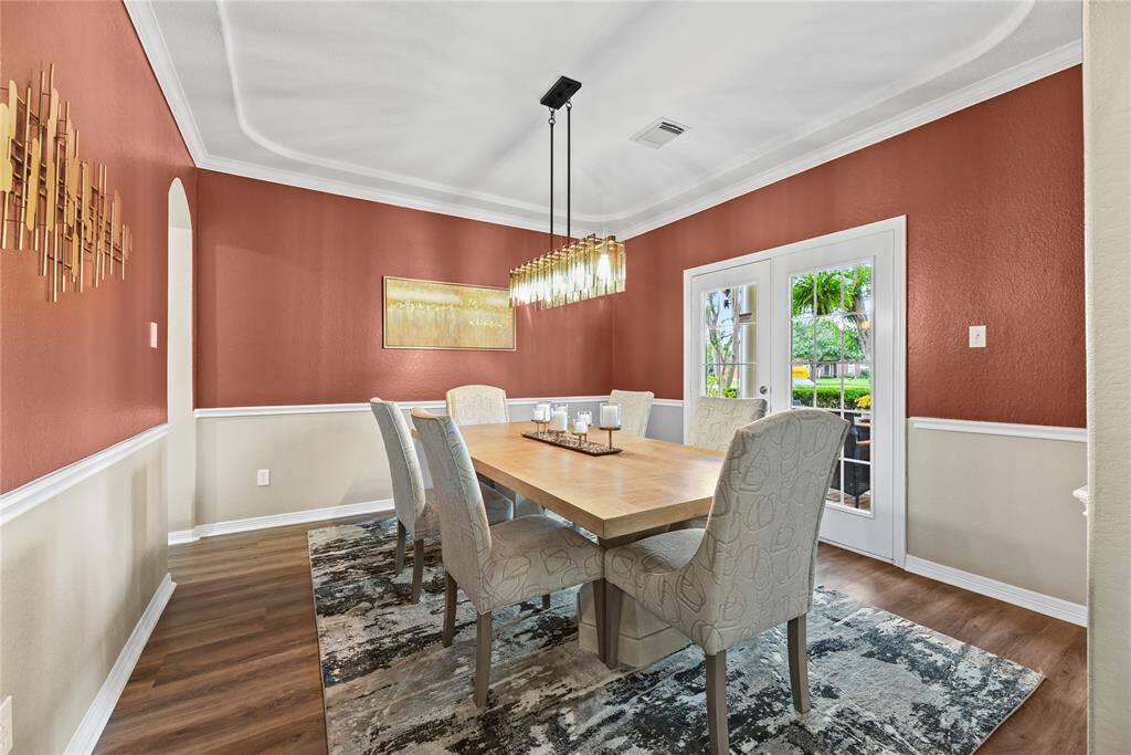 Fanciful dinners or a casual romantic dinner for two are elevated in the formal dining room. Thick white crown molding and the delicate light fixture add just the right amount of opulence for a chic dining experience.