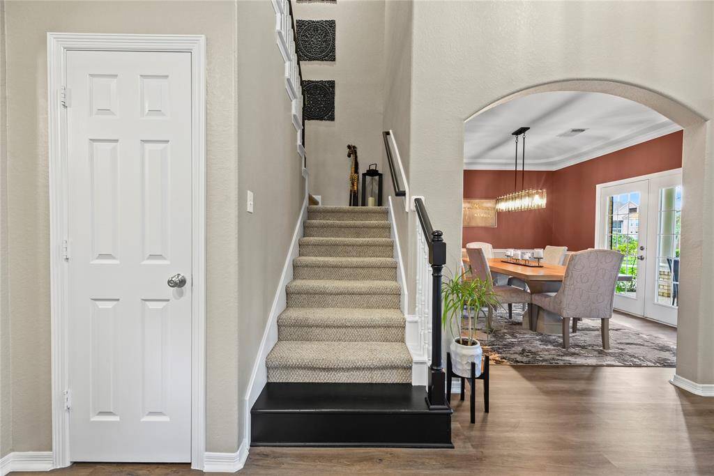 The traditional wooden staircase features bright white spindles, an oak railing, and fully carpeted stairs. Visually, it appears elegant, yet inviting.