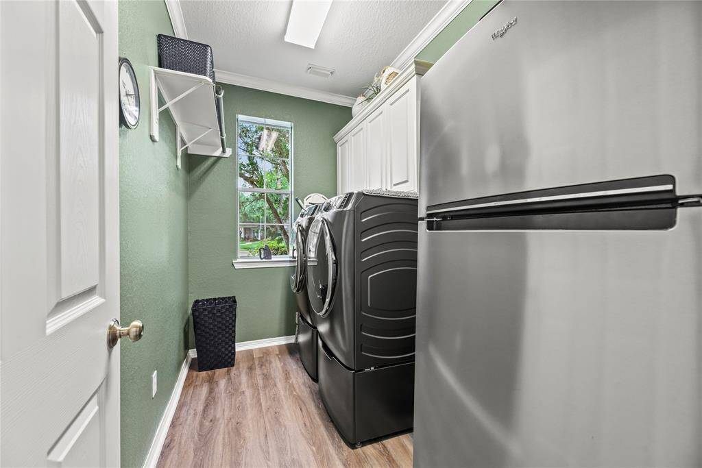 Boasting a laundry room with a hanging bar and a shelf, there is a load of room for cleaning supplies and clothing organization.