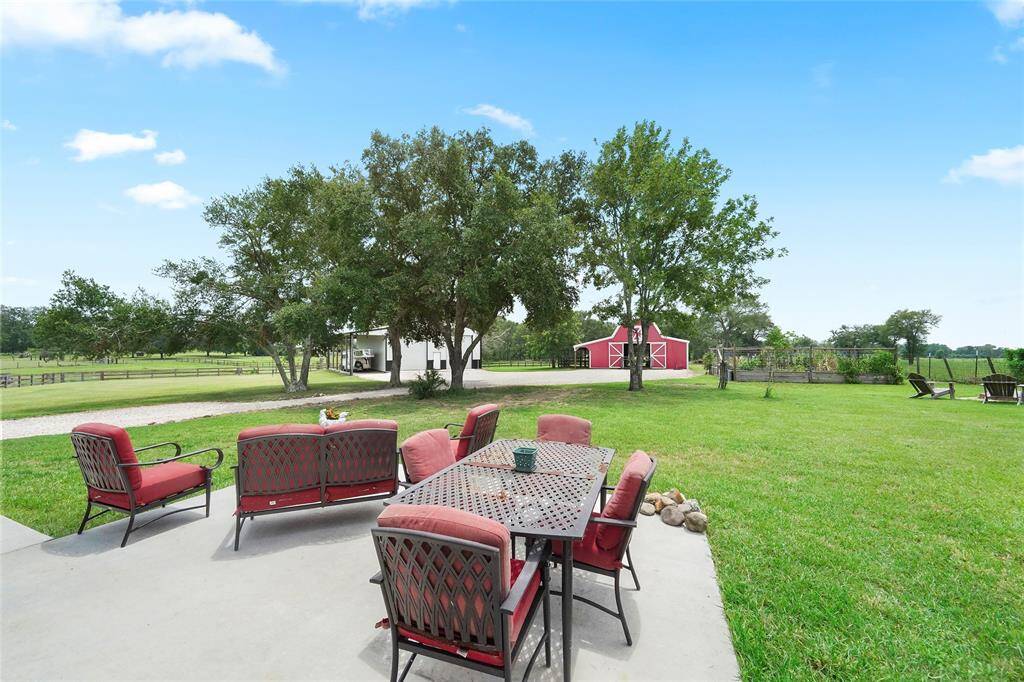 Welcome to your country retreat! Spacious and inviting, the backyard patio is ideal for family gatherings, with open views of the red barn and fenced acreage beyond.