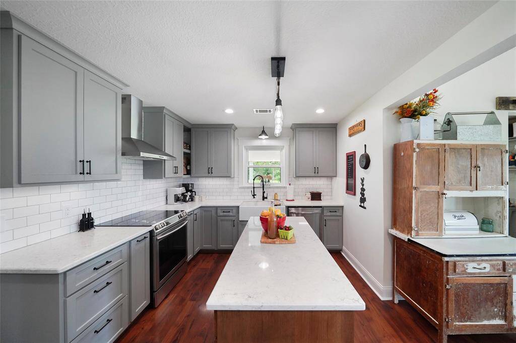 The large center island with bar seating, farmhouse sink, and updated fixtures makes this kitchen as functional as it is beautiful.