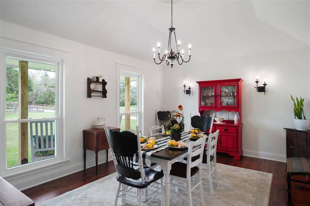 Bright and airy dining space with peaceful pasture views and elegant lighting, offering a charming place to gather and enjoy the scenery.