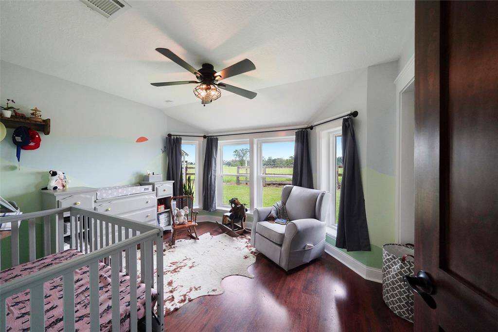 Peaceful and light-filled, this secondary bedroom offers charming views of the pasture and space to relax, rest, or play.