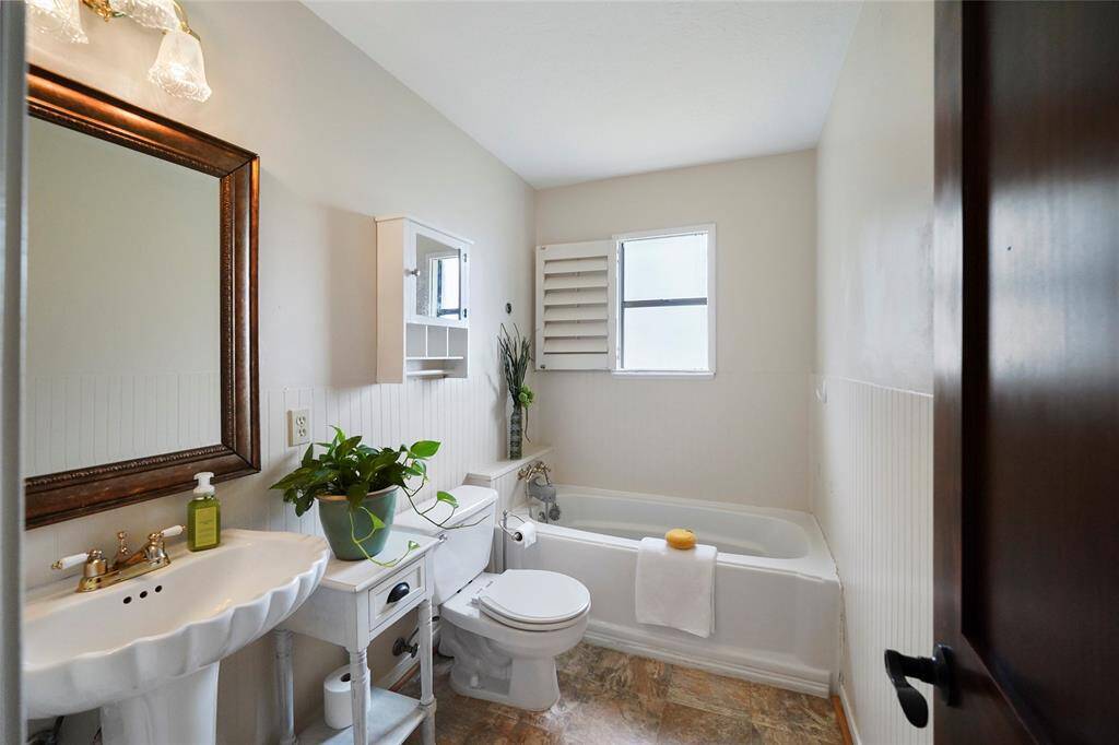 Vintage charm meets modern comfort in the hall bath, with beadboard details and a deep soaking tub.