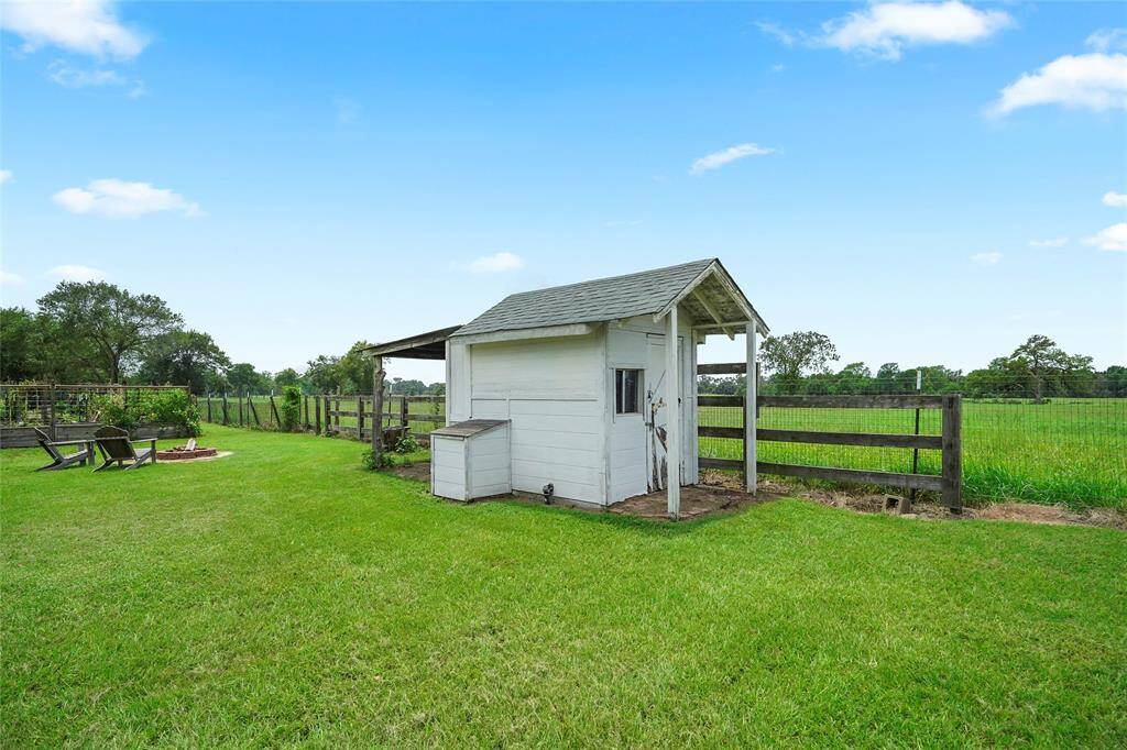 This charming chicken coop sits within the fenced garden area, offering plenty of space for both gardening and small animal care. The surrounding garden beds provide an additional touch of countryside living.
