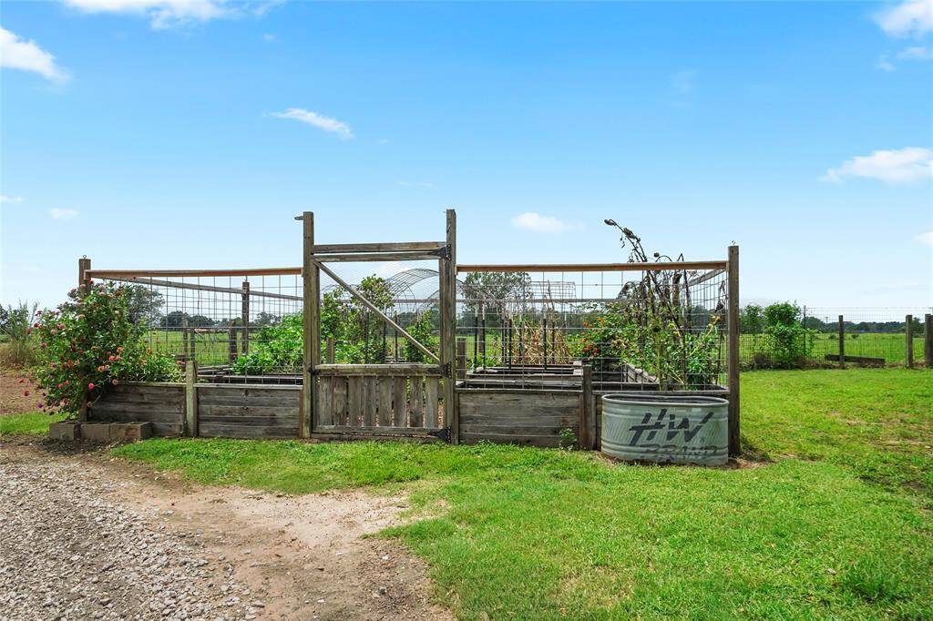 A beautiful garden setup with raised beds and secure fencing, perfect for growing your own produce while maintaining separation from the pastures and horses.